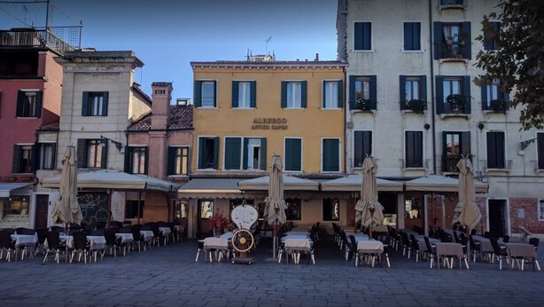 A courtyard with outdoor seating and a building labeled "ALBERGO ANTIPARDO". - Albergo Antico Capon (Venice)