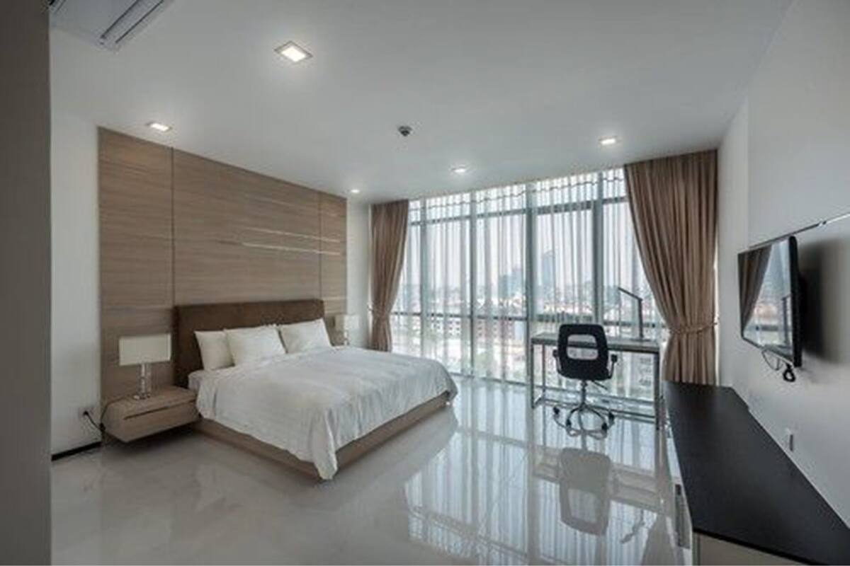 Une chambre d’hôtel moderne avec un grand lit, un bureau et une télévision.