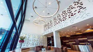 A modern lobby with a glass facade, circular ceiling lights, and a reception desk. - Maline Exclusive Serviced Apartments (Phnom Penh)