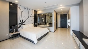 A modern bedroom with a large bed, a built-in TV, and a mirror. - Maline Exclusive Serviced Apartments (Phnom Penh)