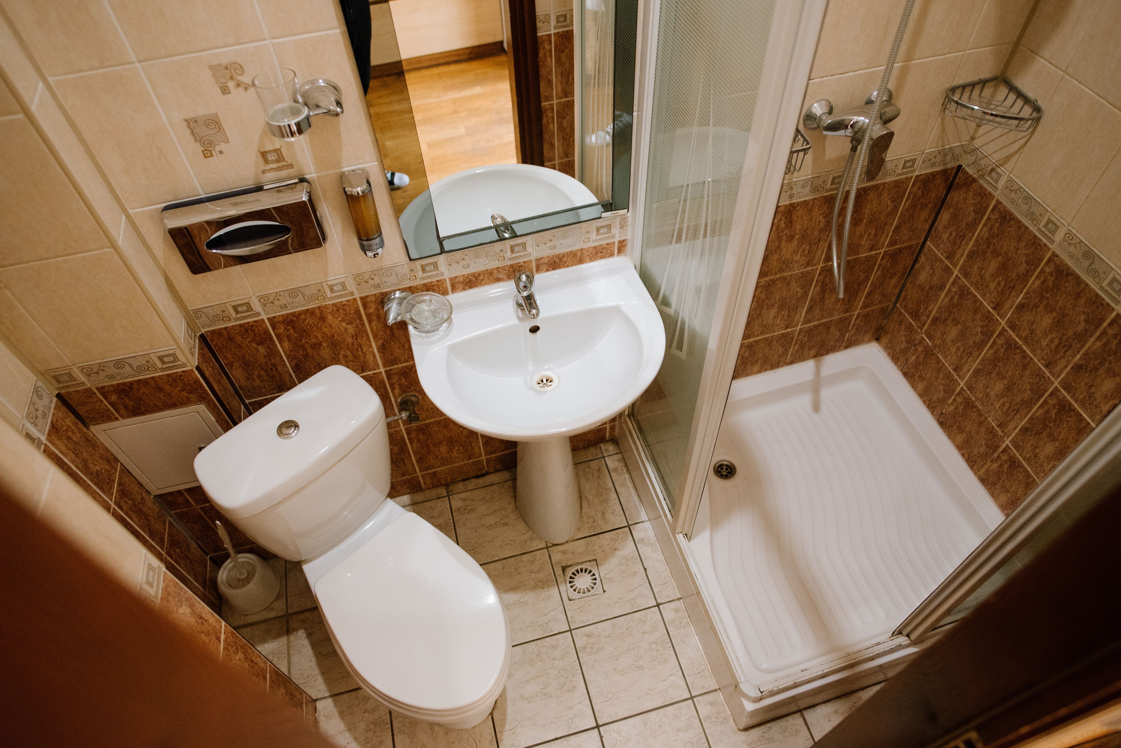 A bathroom with a toilet, sink, and shower.
