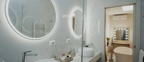 Un baño moderno con dos lavamanos, un espejo grande y un tocador con bañera.