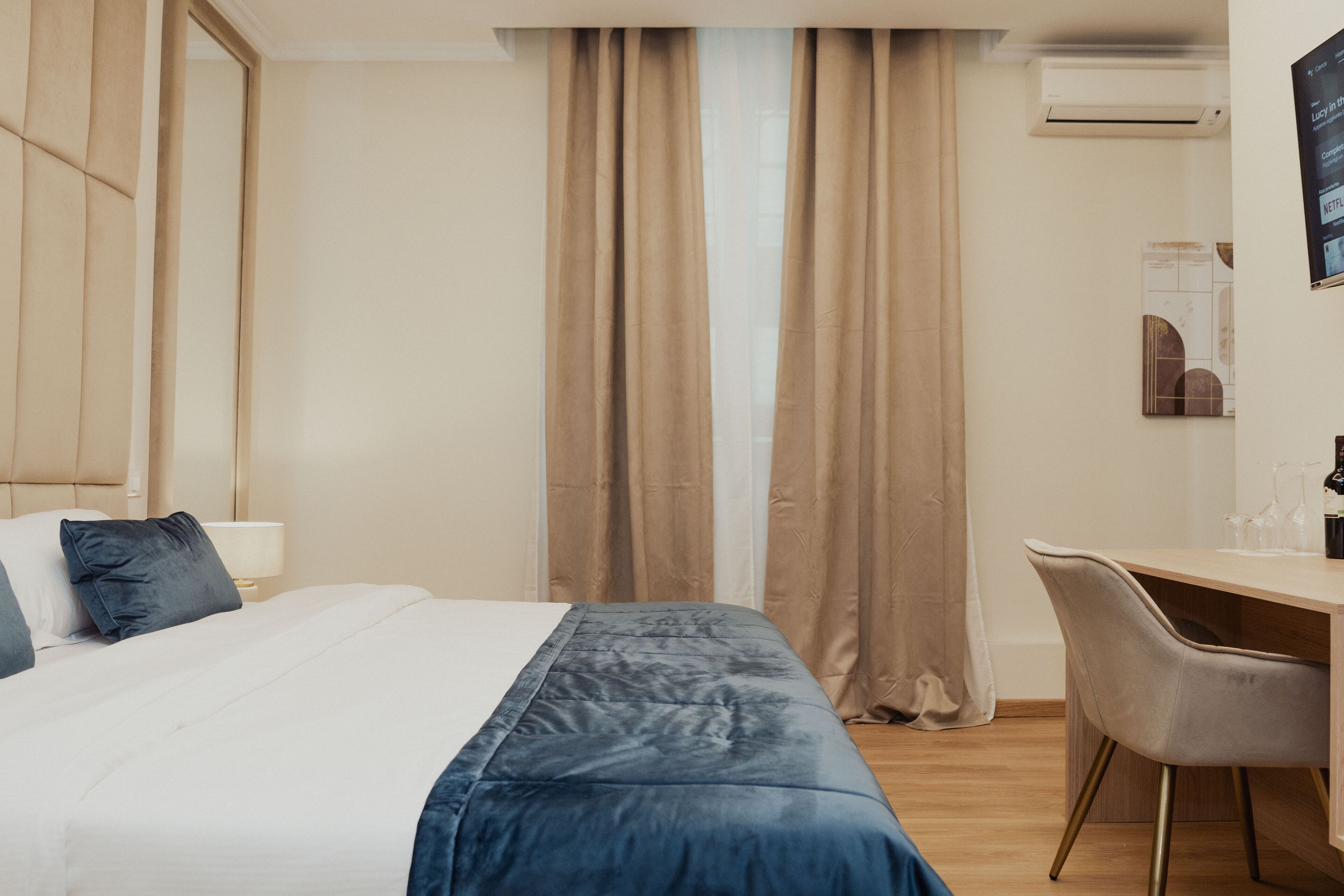 Una camera d'albergo con un letto, una scrivania e una sedia.