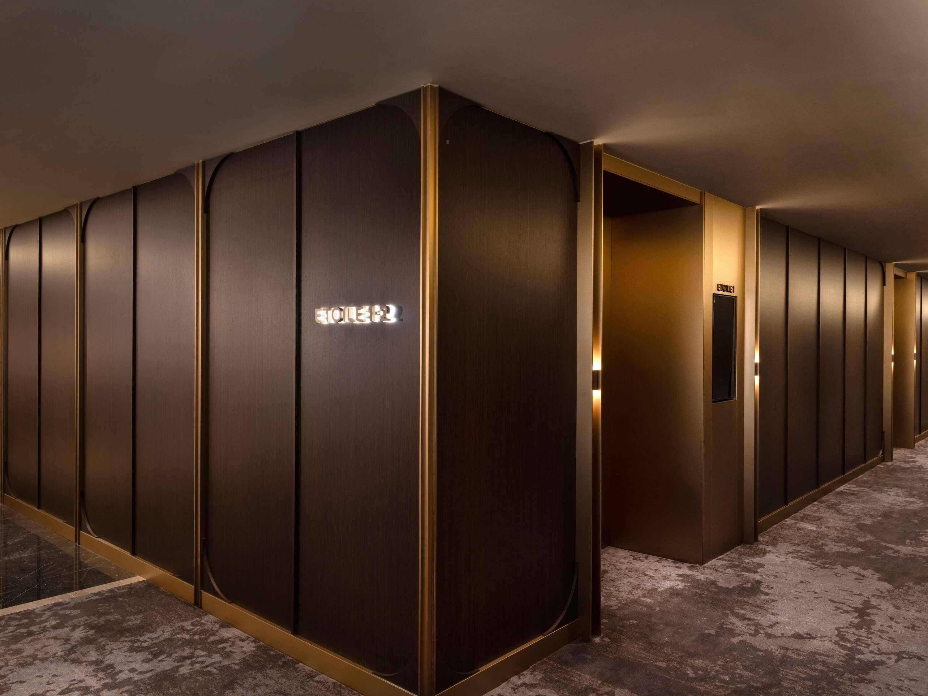 A corridor with a series of doors, one marked 'EATRE' and another with a sign indicating an 'ELECTRIC'.