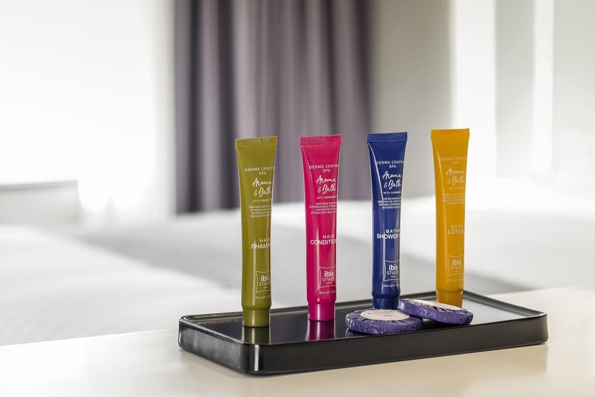 Quatro tubos de produtos capilares e de banho Derma Centrix Spa sobre um tabuleiro preto.