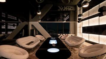 Relax in the stylish lounge area with a central table and comfortable seating, offering a city view.