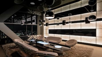A modern lounge with a city view, sleek furniture, and ambient lighting.
