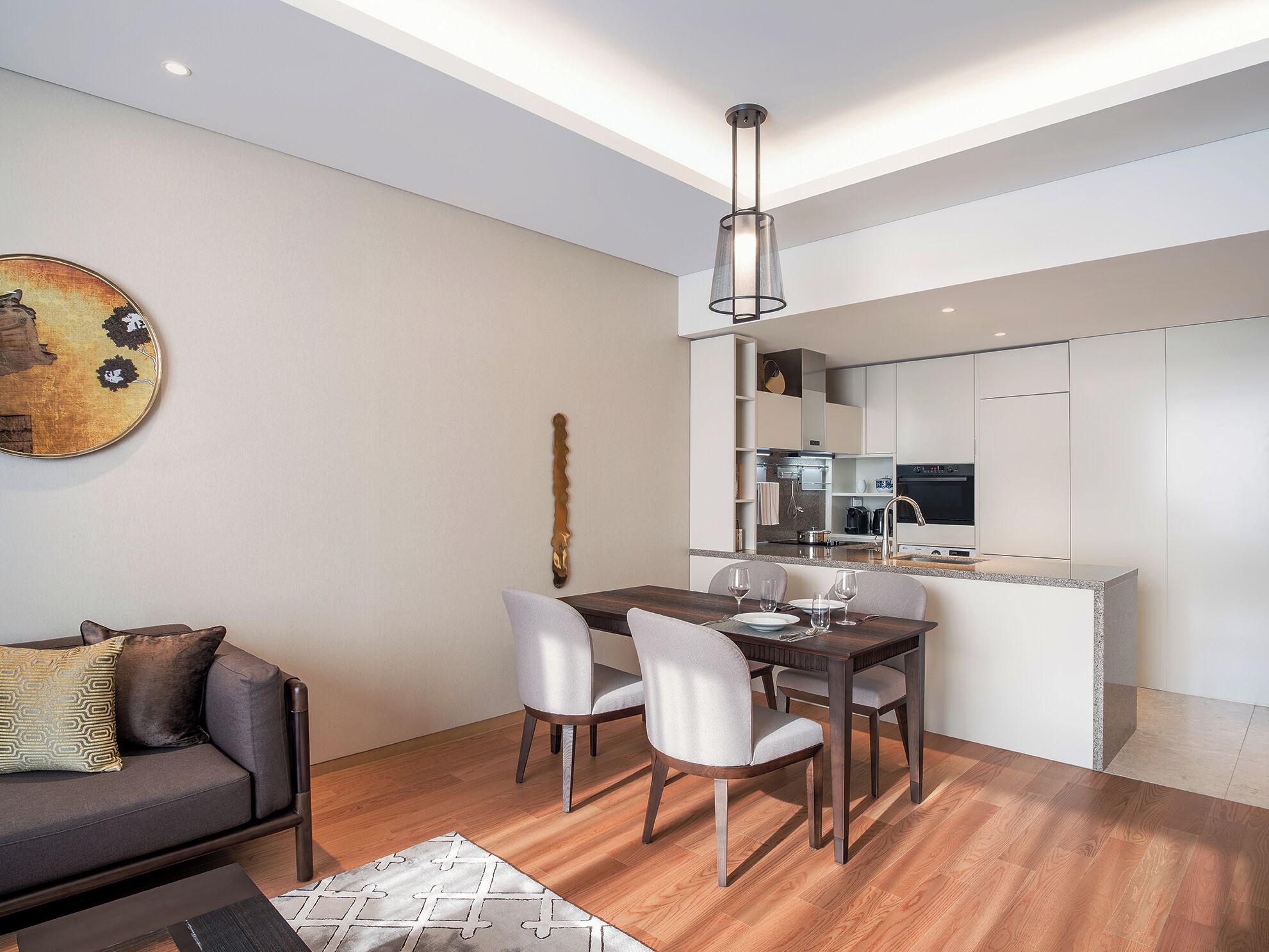 A modern apartment with a dining area, kitchen, and living space.
