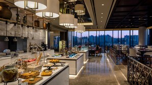A modern hotel lobby with a central bar area, seating arrangements, and a view of the cityscape through large windows. - Grand Mercure Ambassador Hotel and Residences Seoul Yongsan (Seoul)