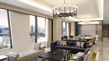 Une chambre d’hôtel moderne offrant une vue imprenable sur la ville, avec un coin repas et un salon comprenant un canapé et une table basse.