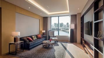 Una habitación de hotel moderna con sofá, mesa de centro y televisión.
