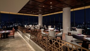 A rooftop bar with a panoramic city view, featuring modern seating and a wooden ceiling. - Grand Mercure Ambassador Hotel and Residences Seoul Yongsan (Seoul)