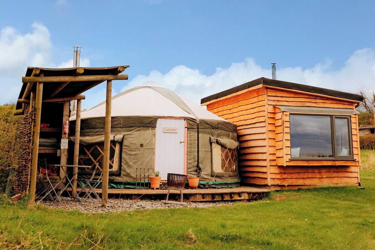 A yurt with a door labeled "Lavender" and a wooden cabin with a window.