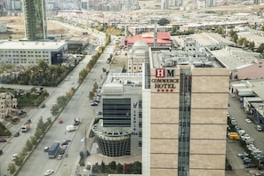A high-rise building with a prominent sign for the "H M Commerce Hotel".