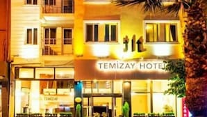 Un hotel de varios pisos con un letrero llamativo que dice 'TEMIZAY HOTEL'.