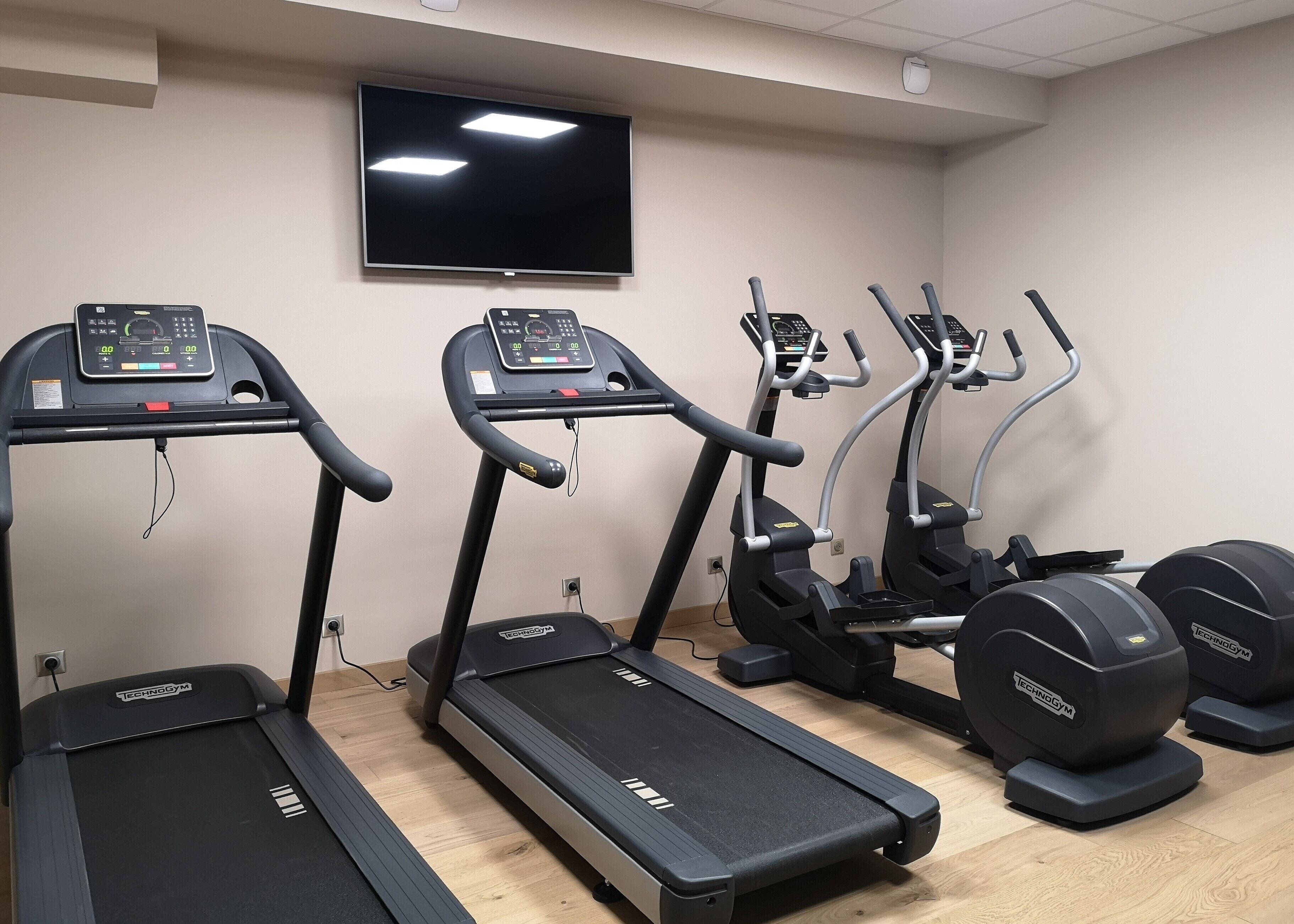 A gym with treadmills, elliptical machines, and weight machines.