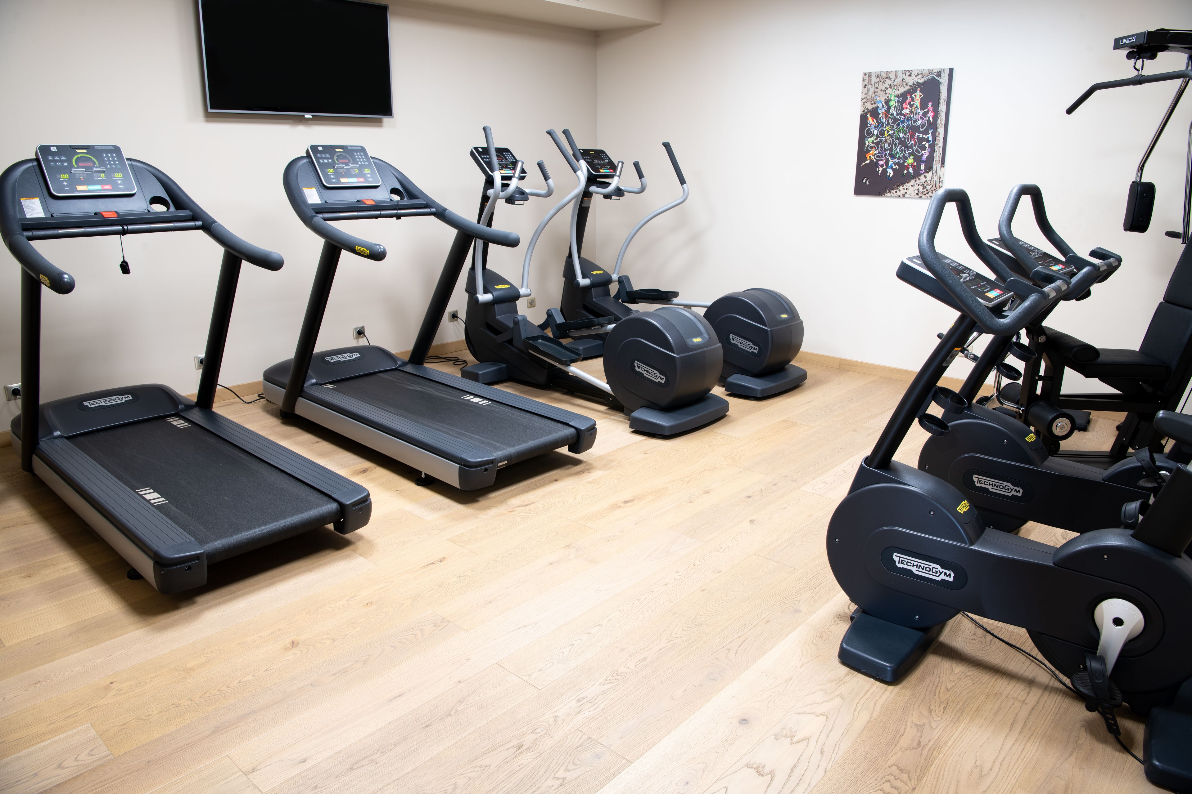 A gym with treadmills, elliptical machines, and a stationary bike.