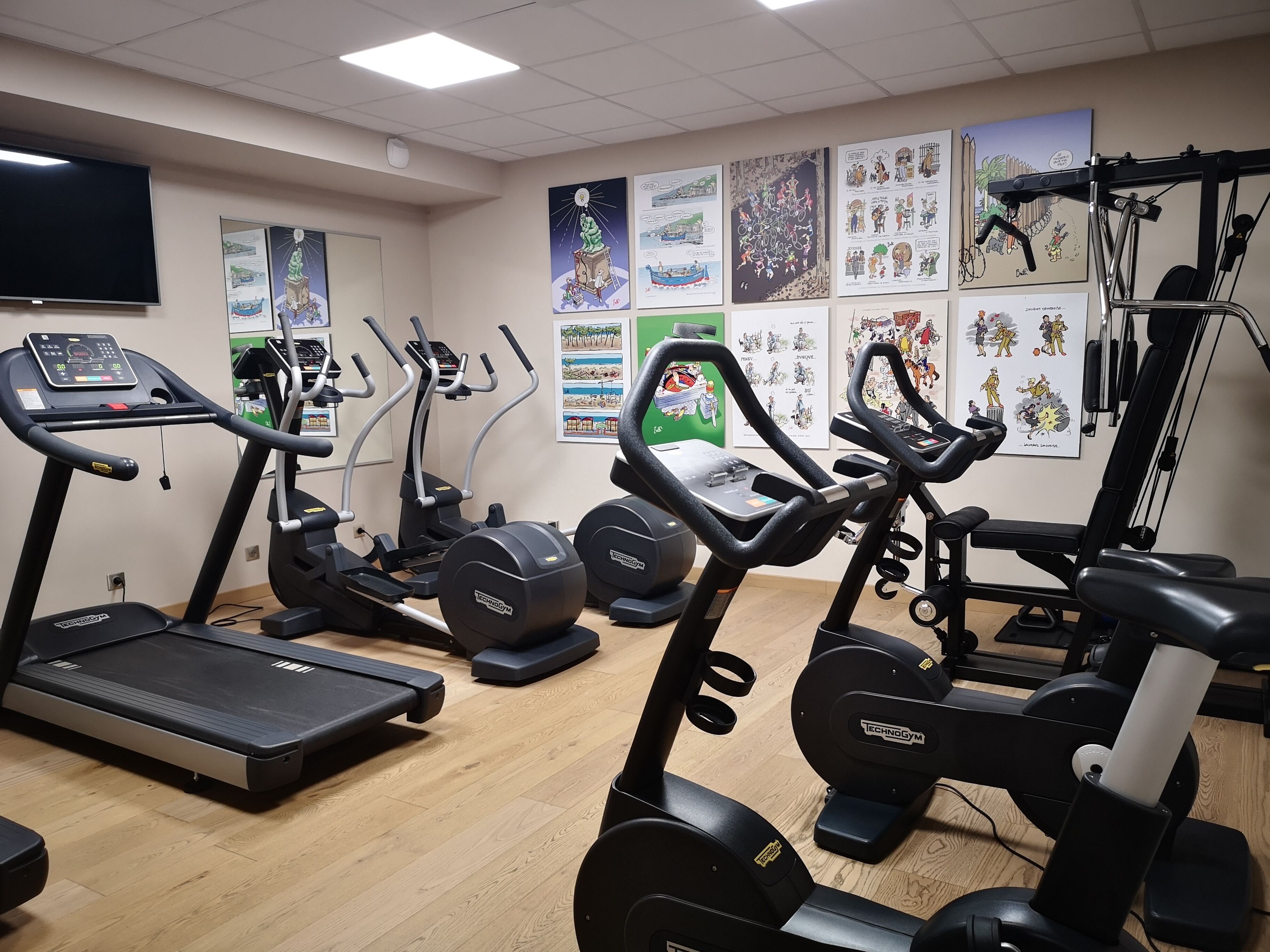 Un gimnasio con cintas de correr, elípticas y estaciones de pesas.