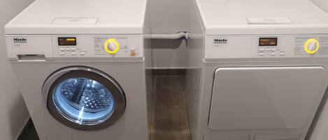 Twee Miele Professional wasmachines naast elkaar in een wasserij.