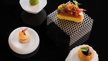 A variety of dessert presentations on white plates with a black background.