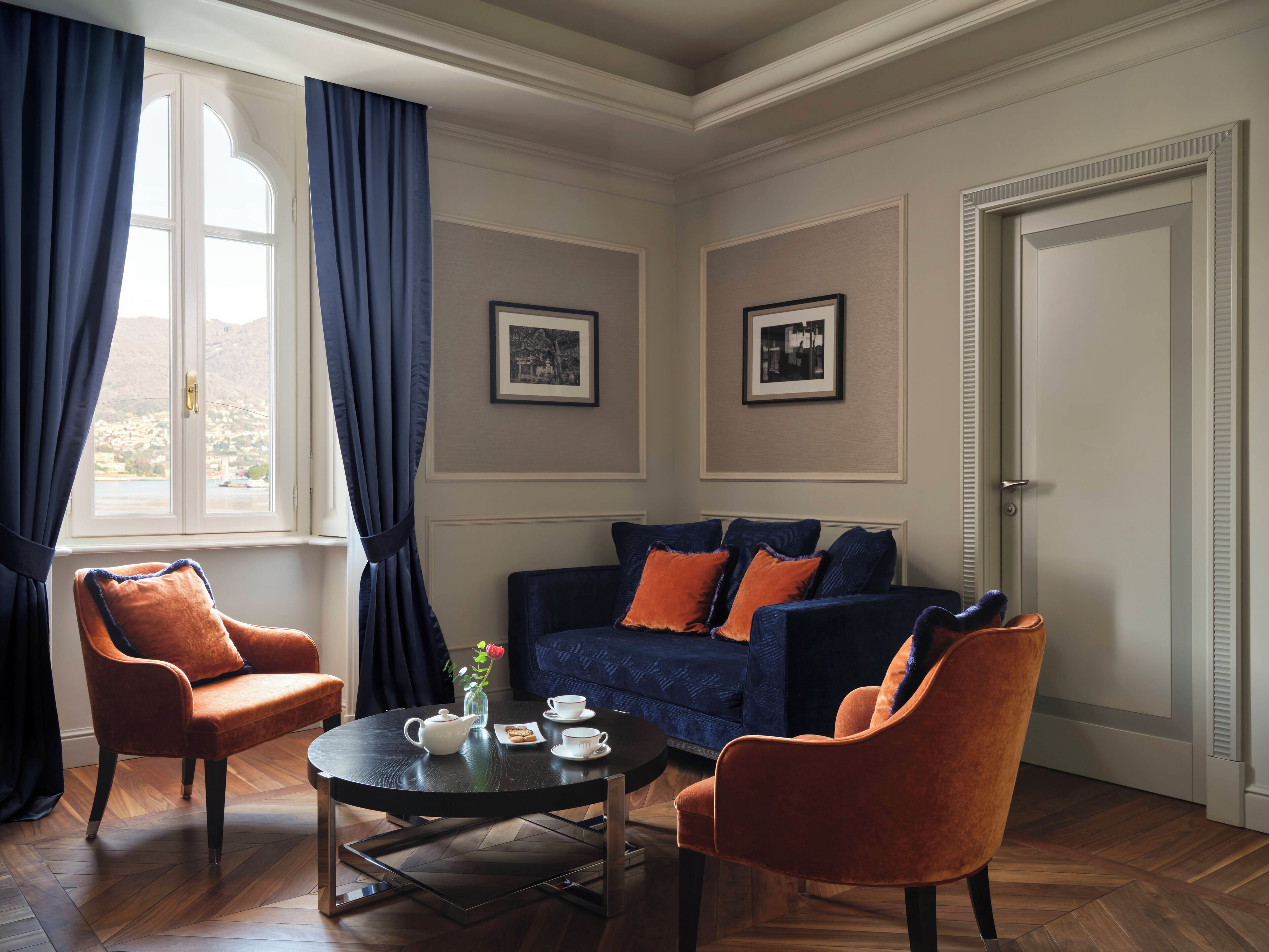 Una habitación con un sofá, dos sillones, una mesita de centro y una puerta.