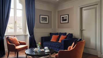 Una habitación con un sofá, dos sillones, una mesita de centro y una puerta.