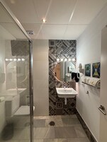 Panoramic Studio | Bathroom | Rainfall showerhead, hair dryer, towels, soap