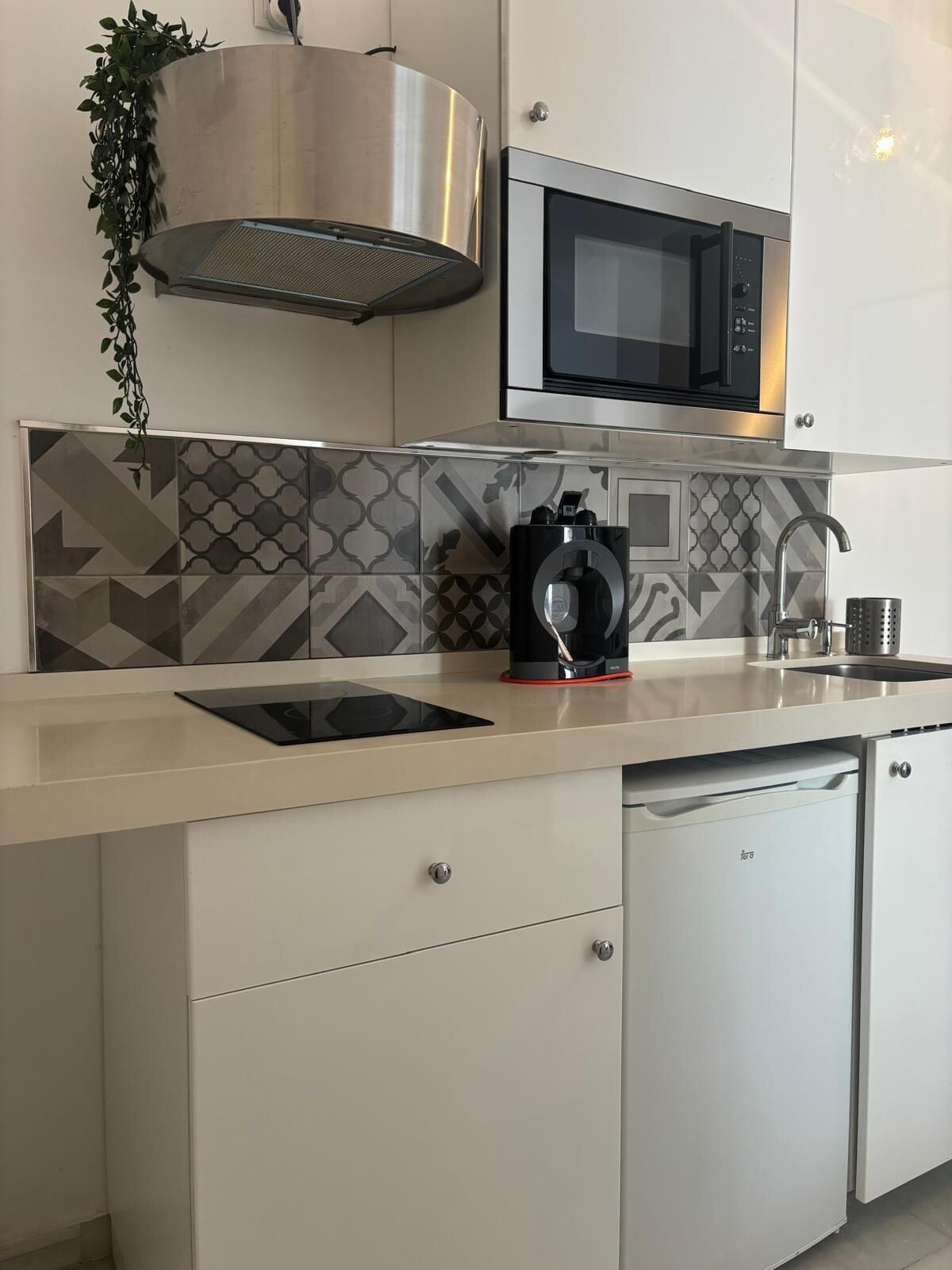 A modern kitchen with a microwave, a coffee machine, and a dishwasher.