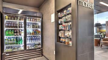 A refrigerated beverage display and a wall-mounted product shelf in a store.
