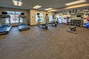 A gym with treadmills, elliptical machines, a bench, and a rack of dumbbells. - Residence Inn by Marriott Blacksburg-University (Blacksburg)