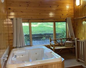 A wooden cabin with a large bathtub, a wooden deck, and a view of the outdoors. - Gunflint Lodge & Outfitters (Grand Marais)