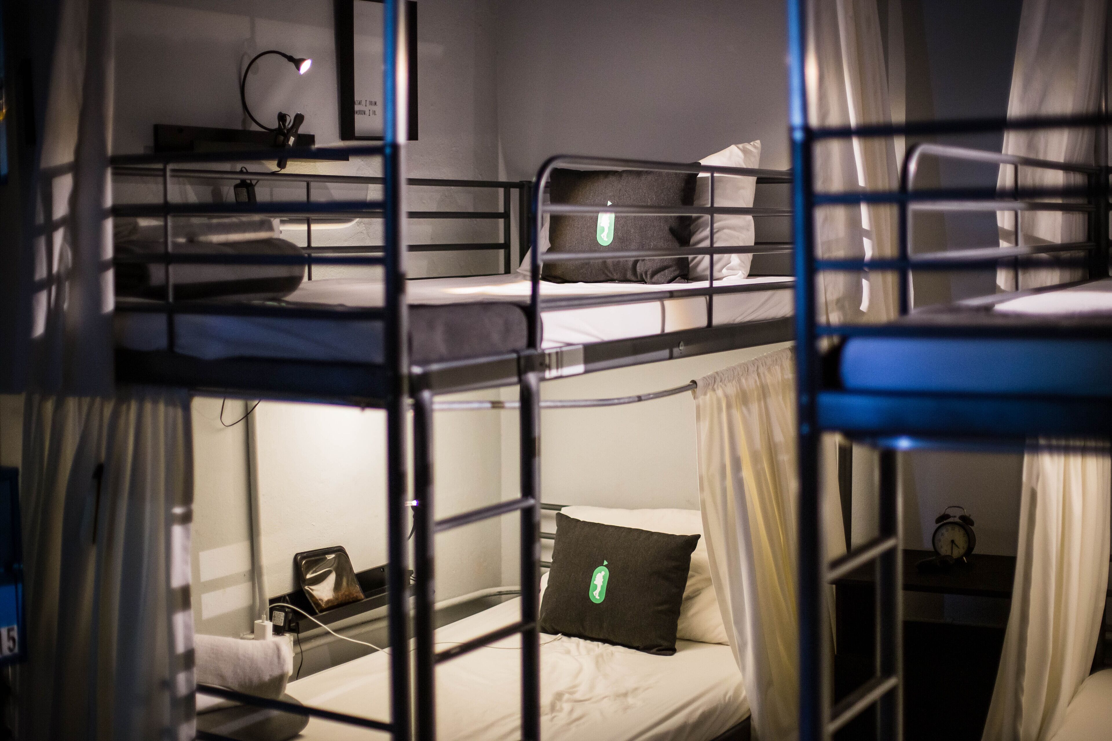 Een slaapkamer met een stapelbed, bureau en nachtkastje.