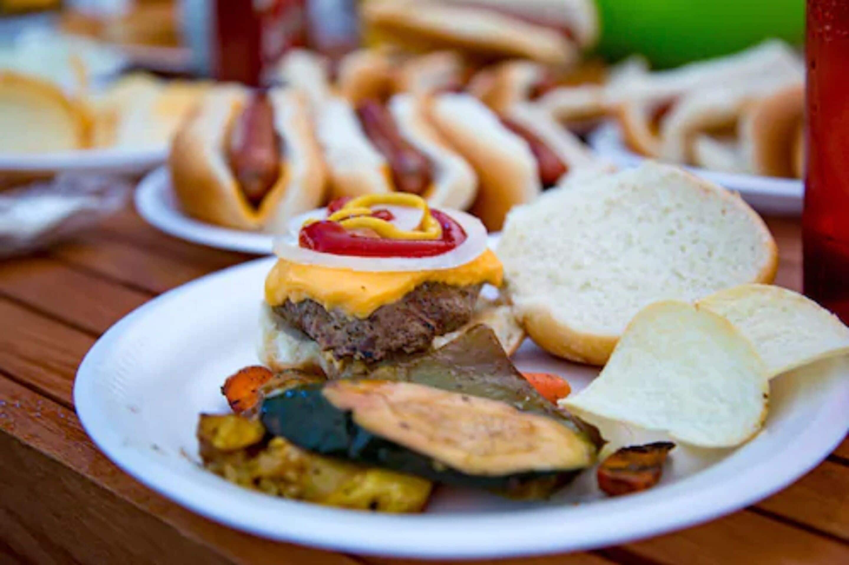 Een bord met een hamburger, groenten en een portie friet.
