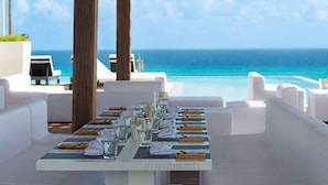 A table set for dining with a view of the ocean.