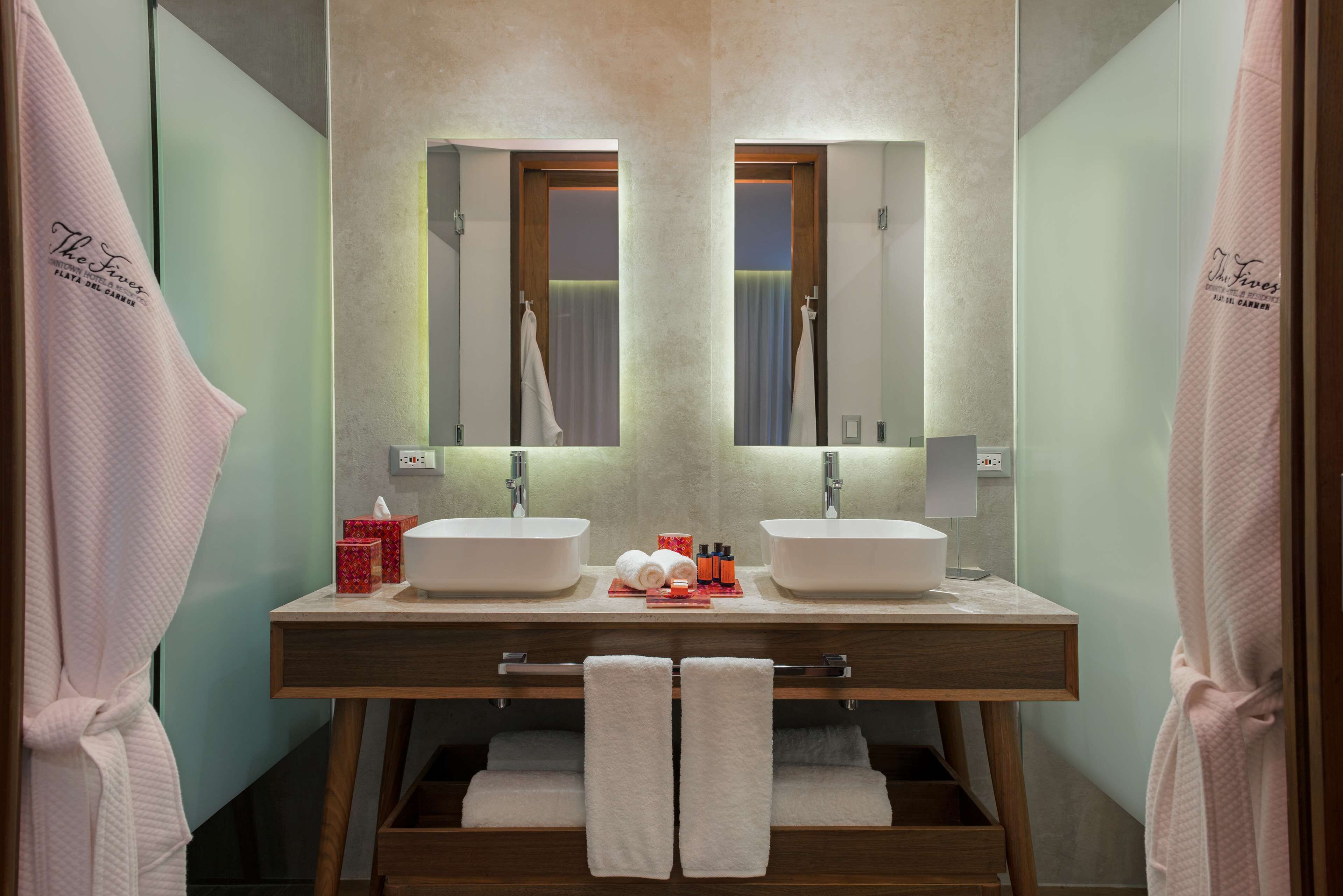 A bathroom with two sinks, a mirror, and a towel rack.