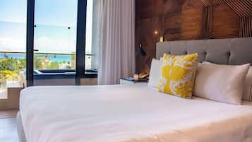 Une chambre d’hôtel avec un grand lit, une vue sur l’océan et un décor mural en bois.