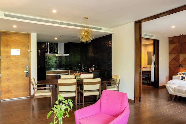 A modern living room with a dining area, a bright chandelier, and a wooden floor. - The Fives Downtown Hotel - Curio Collection by Hilton (Playa del Carmen)