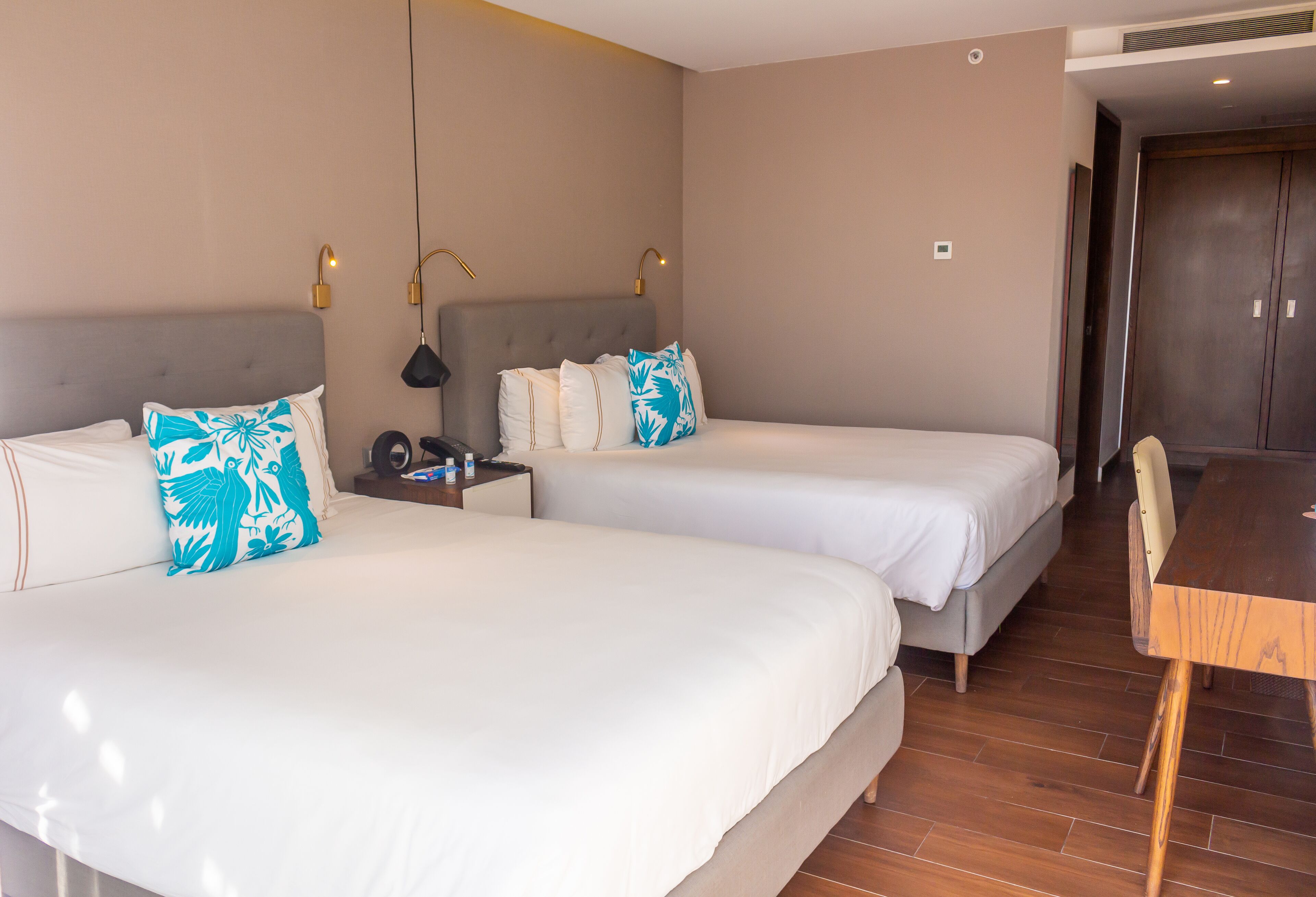 Ein Hotelzimmer mit zwei Betten, einem Holztisch und einem Kleiderschrank.