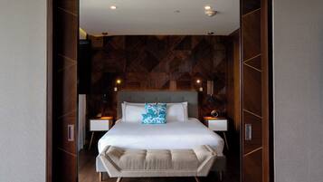 A modern bedroom with a large bed, wooden paneling on the walls, and two bedside tables with lamps.