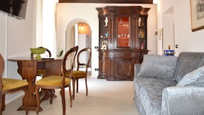 Une pièce comprenant une table à manger en bois, des chaises, un canapé et un meuble.