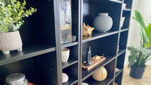 A black bookshelf with various decorative items including a potted plant, a ceramic bowl, and a vase. - Crown Point Beach Oasis - 2 Blocks to the Bay!! (San Diego)