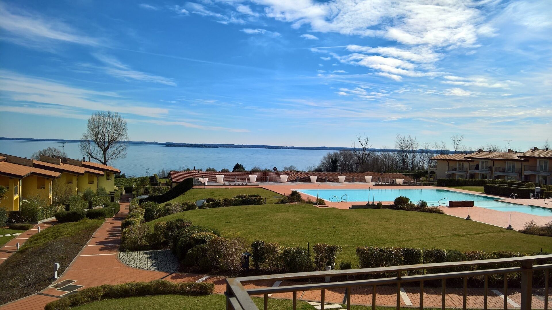Un complexe hôtelier doté d’une piscine, d’une pelouse bien entretenue et offrant une vue sur l’eau.
