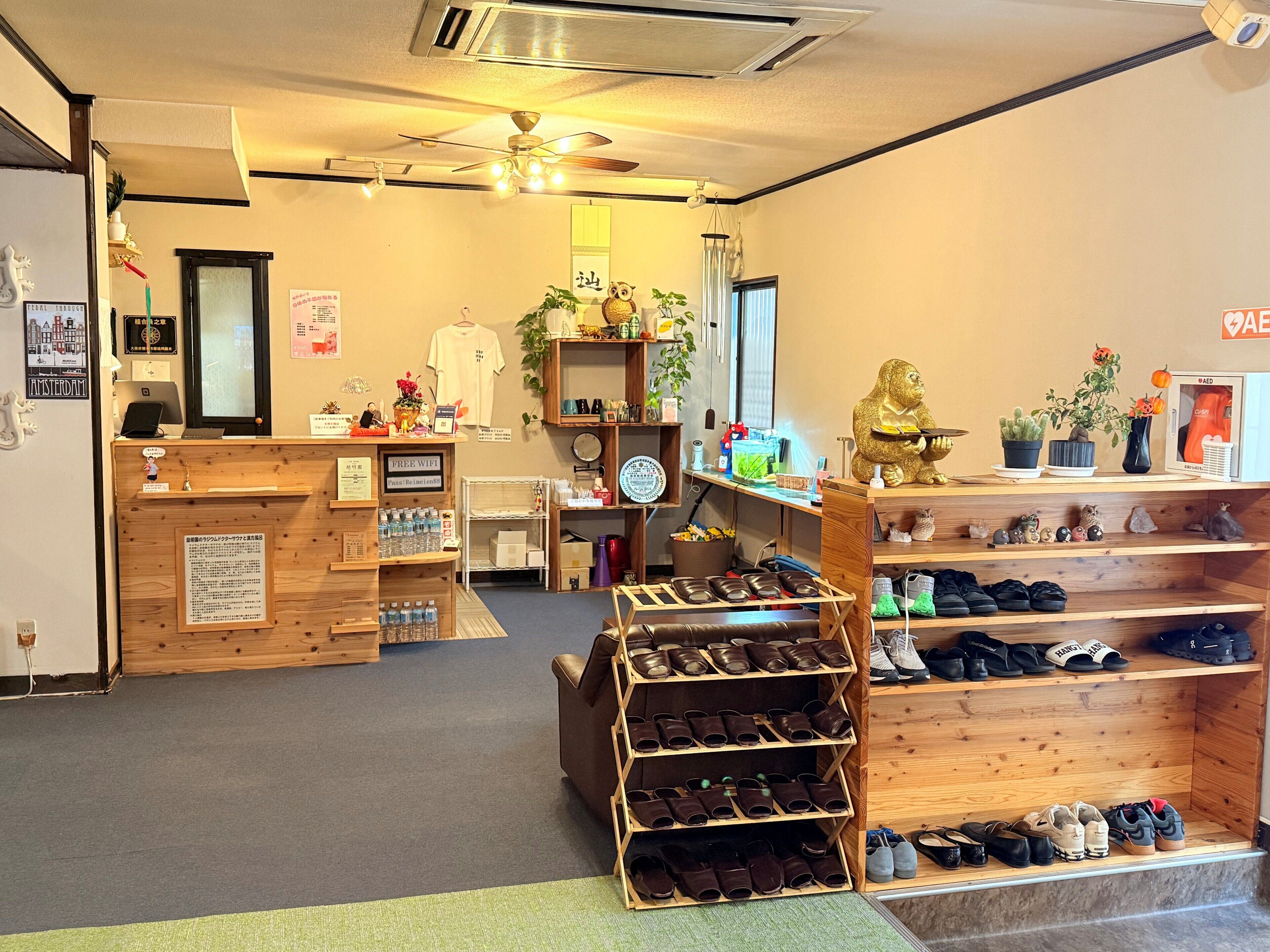 A shoe store with wooden shelves, a reception desk, and a ceiling fan.