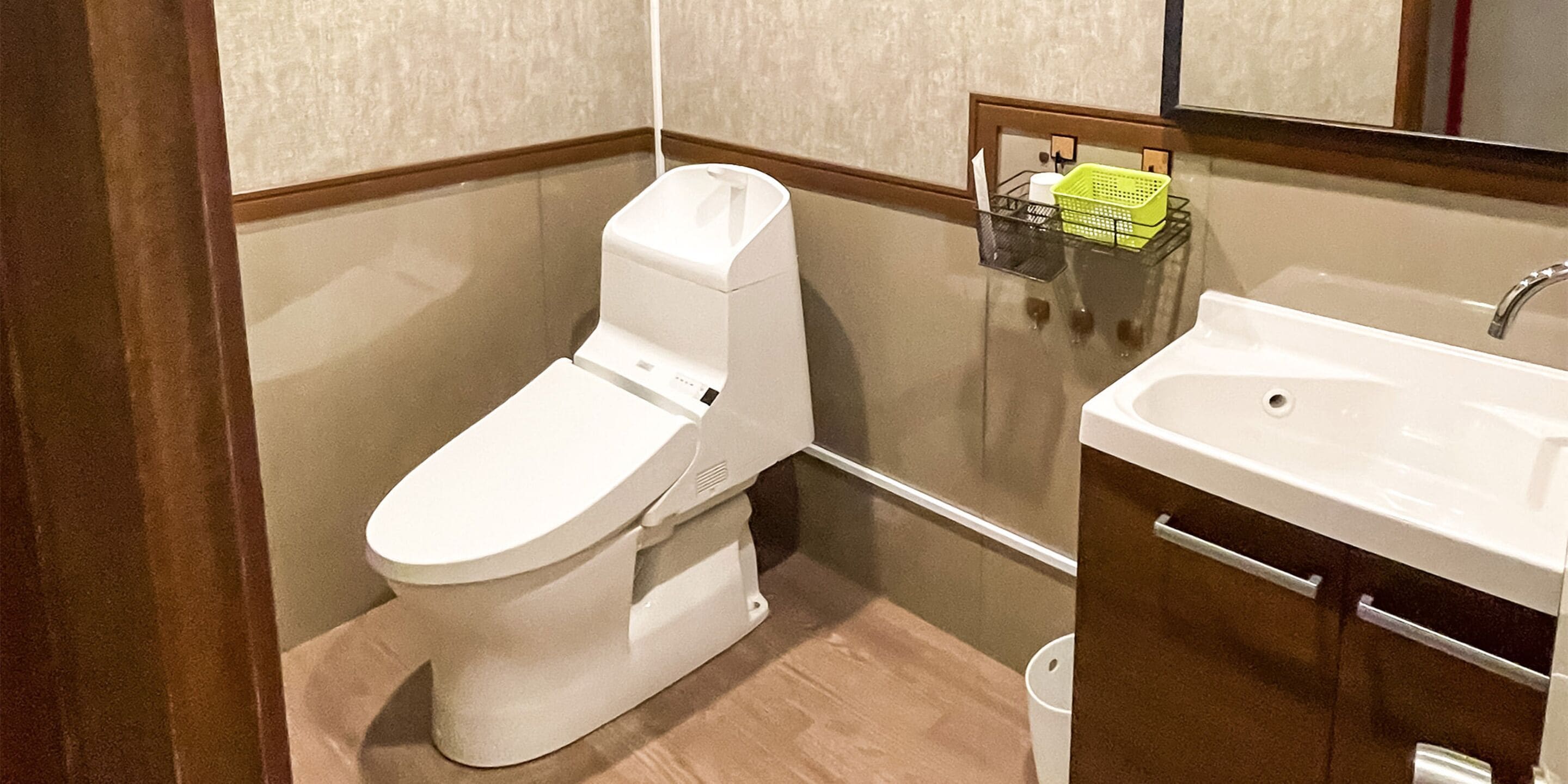 A bathroom with a white toilet, a sink, and a mirror.