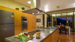 Een moderne keuken met roestvrijstalen apparatuur, houten kastjes en een houten aanrecht vol verse groenten.