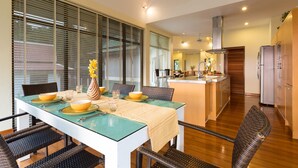 Een moderne keuken met een centraal eiland, houten kastjes en een roestvrijstalen koelkast.