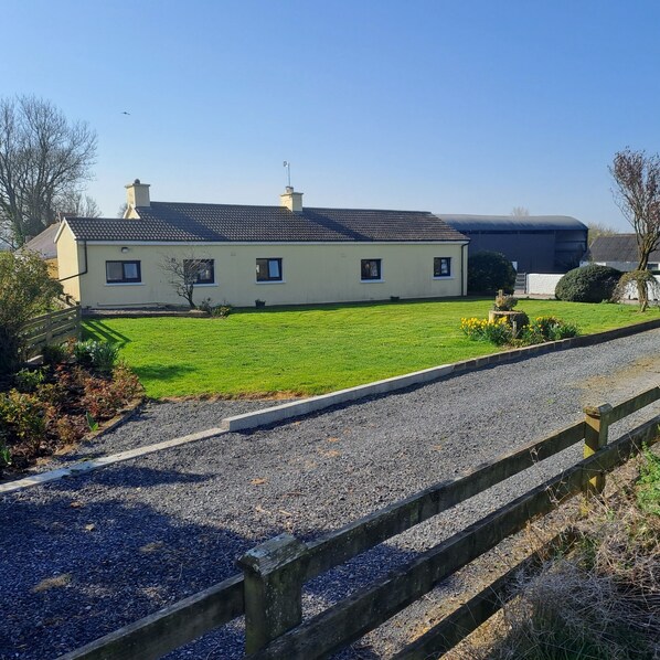 A two-story house with a tiled roof, a large barn, and a well-maintained lawn. - Old Style Traditional Irish Farmhouse with mod-cons- WIFI included as standard (Limerick)