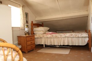 A bedroom with a single bed, a wooden dresser, a radiator, and a window with curtains. - Old Style Traditional Irish Farmhouse with mod-cons- WIFI included as standard (Limerick)