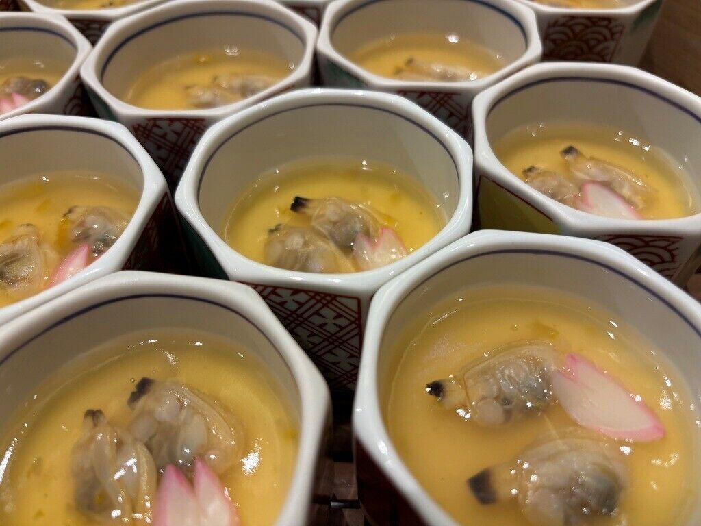 Multiple bowls of soup with visible ingredients like mushrooms and radish.