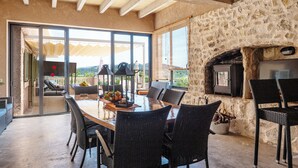 An outdoor dining area with a stone wall, a fireplace, and a view of the landscape. - quiet farm to relax 1km from Son Macia (SON MACIA      MANACOR)